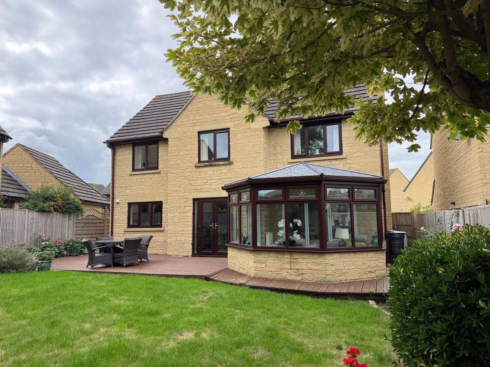 Cotswold stone house in Cheltenham with a P-shaped conservatory and new grey tiled Ultraroof