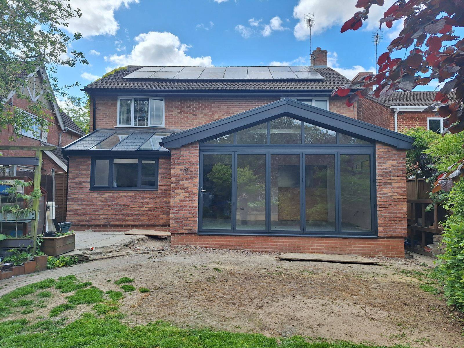 Single-storey HUP house extension in Gloucester with a glazed gable and grey bi-fold doors