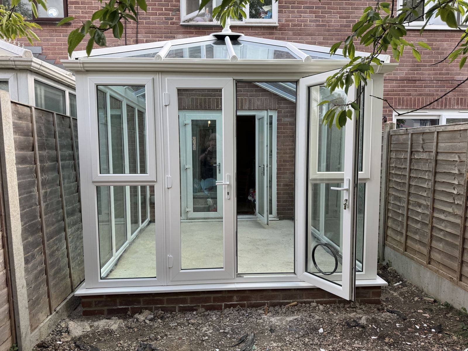 New white conservatory in Tewkesbury with a glass roof and open French doors