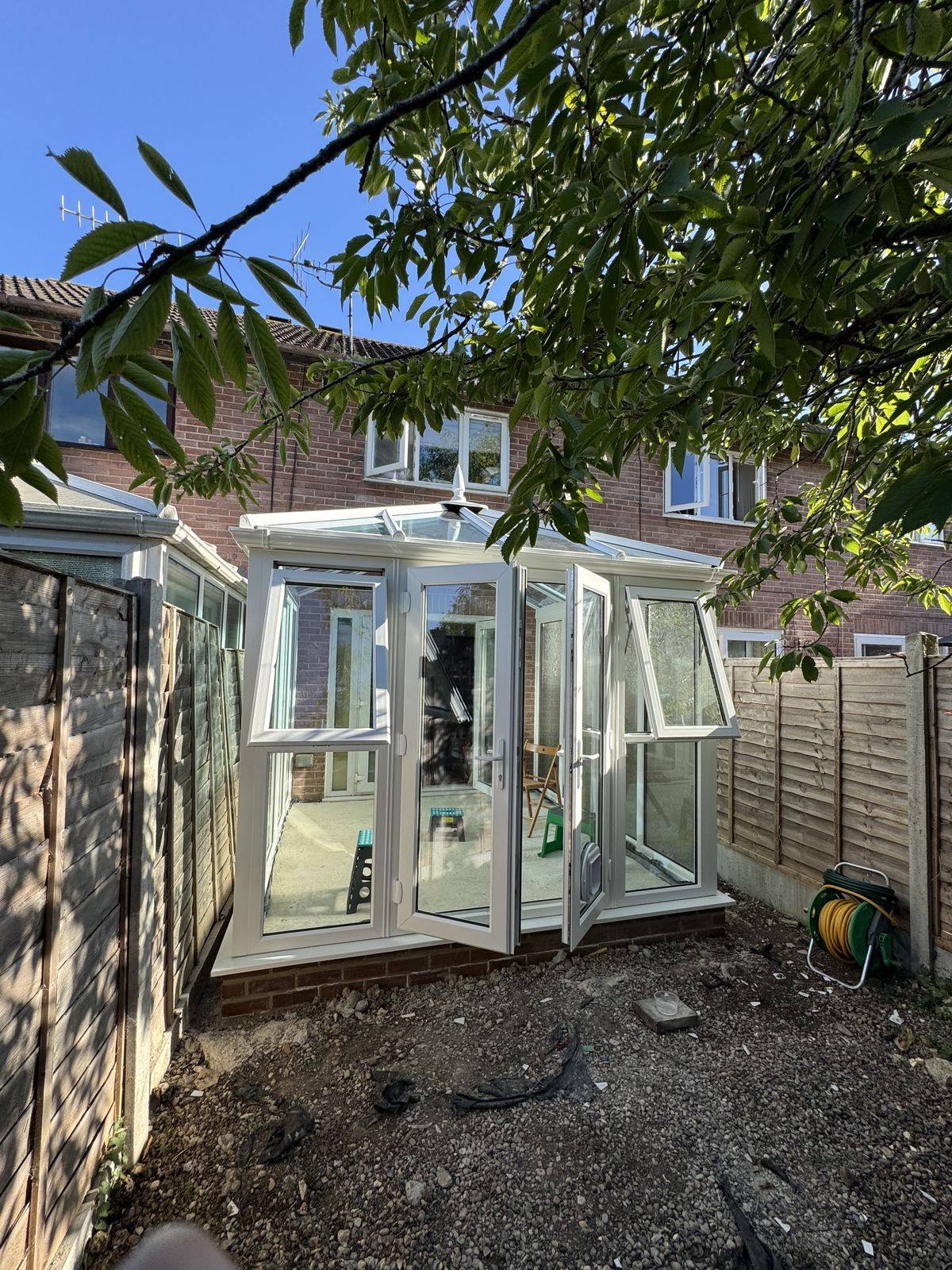 New glass-roof conservatory on a brick dwarf wall at the back of a house in Tewkesbury